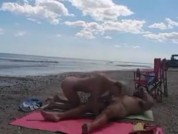 Un couple baise en public sur la plage